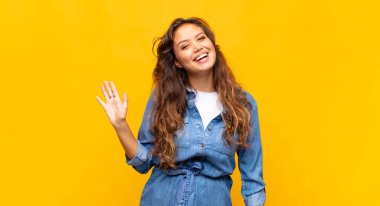 Mutlu bir şekilde gülümseyen, el sallayan, seni selamlayan, ya da hoşça kal diyen bir kadın.