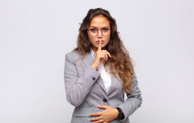 Kadın ciddi görünüyor ve parmaklarını dudaklarına bastırıyor sessizlik ya da sessizlik talep ediyor, sır saklıyor.