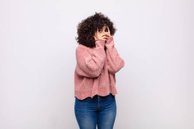 Kadın korkmuş ya da utanmış hissediyor. Gözleri yarı kapalı ya da ellerle dikizliyor.