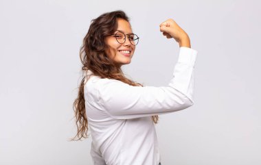 Kadın kendini mutlu, tatmin olmuş ve güçlü hissediyor, kaslı ve formda, spor salonundan sonra güçlü görünüyor.