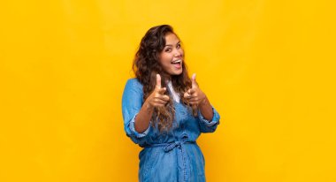 Kadın kendini mutlu, havalı, tatmin olmuş, rahat ve başarılı hissediyor, kameraya bakıyor, seni seçiyor.