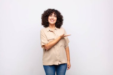 Neşeli bir şekilde gülümseyen, mutlu hisseden ve fotokopi alanında avucunun içinde bir konsept gösteren bir kadın.