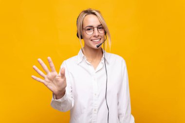 Genç bayan tele pazarlamacı gülümsüyor ve arkadaş canlısı görünüyor. 5 ya da 5 numarayı gösteriyor.