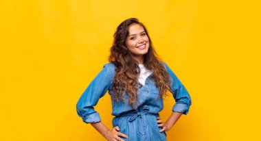 Kadın neşeli bir şekilde gülümsüyor, pozitif, mutlu, kendine güvenen ve rahat bir ifadeyle.