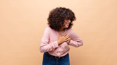 Üzgün, yaralı ve kalbi kırık bir kadın, iki elini de kalbe yakın tutuyor, ağlıyor ve bunalımda.