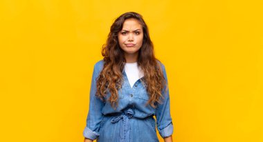 Kadın kendini şaşkın ve şüpheli hissediyor, merak ediyor ya da karar vermeye çalışıyor.