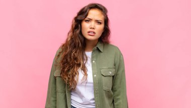 Woman feeling puzzled and confused, with a dumb, stunned expression looking at something unexpected