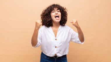 Kadın mutlu, pozitif ve başarılı hissediyor, zaferi, başarıları ya da iyi şansı kutluyor.