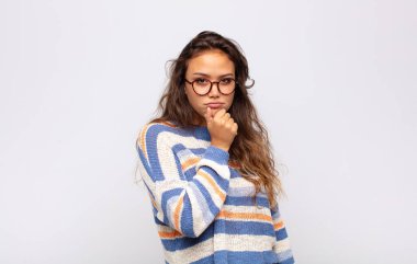 Kadın ciddi görünüyor, kafası karışık, kararsız ve düşünceli, seçenekler ve seçimler arasında şüpheci.