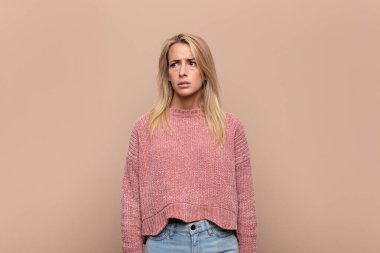 Kadın üzgün, üzgün ya da kızgın ve olumsuz bir tavır takınıyor, anlaşmazlık içinde kaşlarını çatıyor.