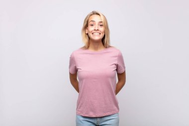 Kadın mutlu ve şapşal görünüyor. Geniş, eğlenceli, kaçık bir gülümseme ve açık gözlerle.