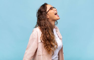 Kadın öfkeyle bağırıyor, agresif bağırıyor, stresli ve kızgın görünüyor.