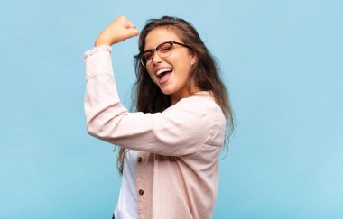 Kadın kendini mutlu, tatmin olmuş ve güçlü hissediyor, kaslı ve formda, spor salonundan sonra güçlü görünüyor.