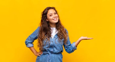 Gülümseyen, kendinden emin, başarılı ve mutlu hisseden bir kadın, fotokopi alanında fikir veya konsept gösteriyor.