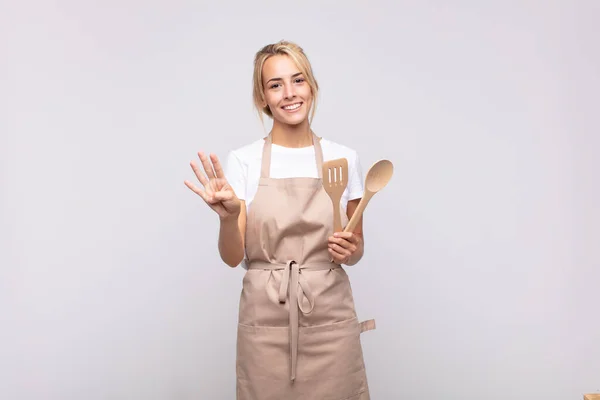 年轻的女厨师面带微笑 面容友善 双手朝前看四号或四号 倒计时 — 图库照片