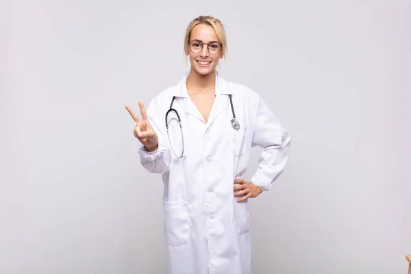 Jovem Médico Sorrindo Olhando Amigável Mostrando Número Dois Segundo Com — Fotografia de Stock