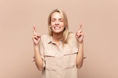 Kadın gergin ve umutlu, şans diliyor ve dua ediyor.