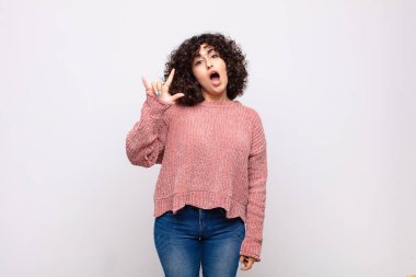 Kadın mutlu, eğlenceli, kendinden emin, pozitif ve asi hissediyor, elle kaya veya heavy metal işareti yapıyor.