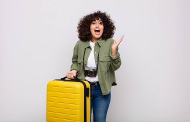 Genç Arap kadın mutlu, heyecanlı, şaşırmış ya da şok olmuş hissediyor, gülümsüyor ve inanılmaz bir seyahat konseptine hayret ediyor.