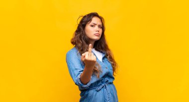 Öfkeli, sinirli, asi ve agresif hisseden bir kadın. Orta parmağını sallıyor, karşı koyuyor.