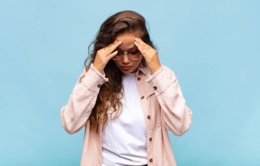 Stresli ve hayal kırıklığına uğramış bir kadın, baskı altında çalışıyor, başı ağrıyor ve sorunları var.