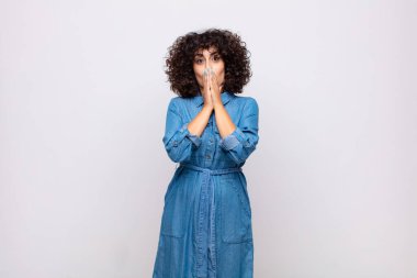 Kadın endişeli, üzgün ve korkmuş, elleriyle ağzını kapatıyor, endişeli ve berbat görünüyor.