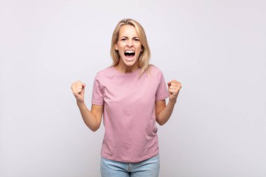 Öfkeli bir ifadeyle ya da yumruklarıyla başarıyı kutlayan bir kadınla.