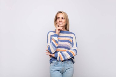 Mutlu bir şekilde gülümseyen, hayal kuran ya da şüpheyle bakan bir kadın.