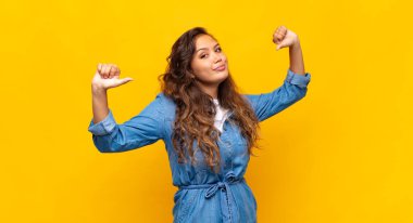 Kadın gururlu, kibirli ve kendinden emin, tatmin olmuş ve başarılı görünüyor, kendini işaret ediyor.