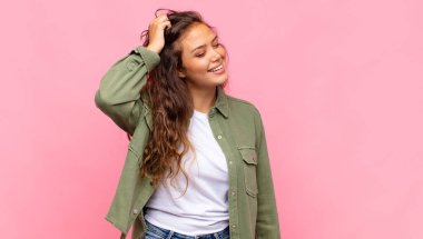 Neşeli ve tesadüfen gülümseyen bir kadın, olumlu, mutlu ve kendinden emin bir bakışla göğüs göğüse tutuşuyor.