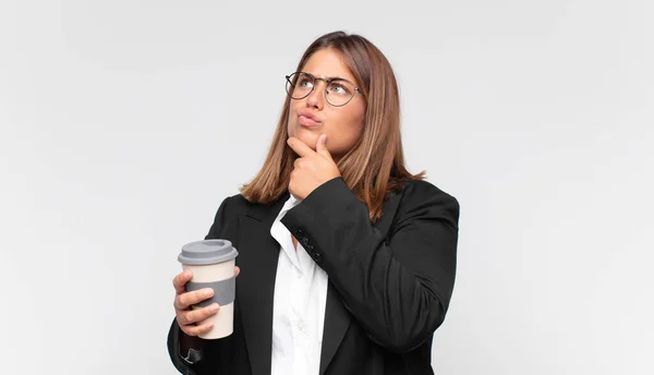 Junge Geschäftsfrau Mit Kaffeesatz Zweifelnd Und Verwirrt Mit Verschiedenen Optionen — Stockfoto