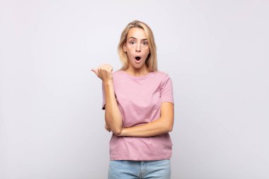 Kadın inançsızlıktan şaşkın şaşkın bakıyor, yan taraftaki objeyi işaret ediyor ve diyor ki: