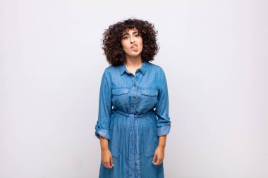 Woman feeling puzzled and confused, with a dumb, stunned expression looking at something unexpected