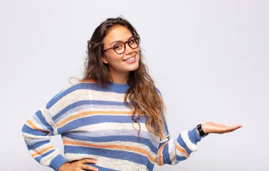 Gülümseyen, kendinden emin, başarılı ve mutlu hisseden bir kadın, fotokopi alanında fikir veya konsept gösteriyor.