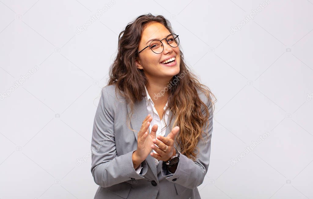 Woman feeling happy and successful, smiling and clapping hands, saying congratulations with an applause
