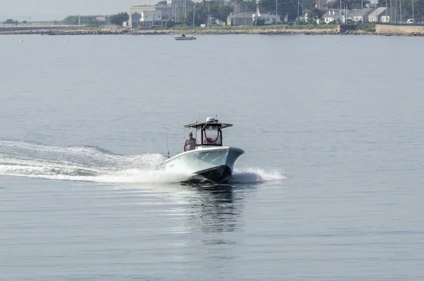 New Bedford, Massachusetts, USA - July 2, 2018: Recreational fishing boat cutting across New Bedford outer harbor on calm morning