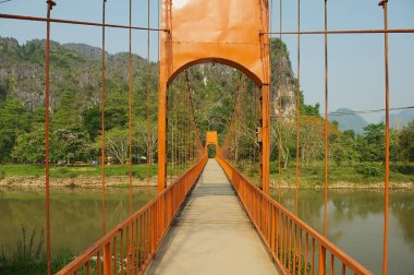 Vang Vieng, Laos - 21 Nisan 2012: Asma Yaya Köprüsü Vang Vieng, Laos Tham Chang mağarada ile doğal kireçtaşı karst Dağları ile Nam şarkı Nehri üzerinde.