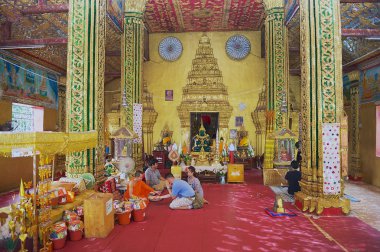 Vientiane, Laos - 22 Nisan 2012: Vientiane, Laos Wat Si Muang Budist Tapınağı'nda bir adak kimliği belirsiz kişi olun