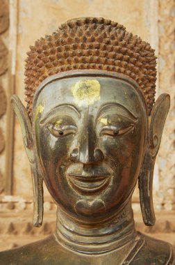 Vientiane, Laos - 23 Nisan 2012: Vientiane, Laos (eski Tapınağı Emerald Buda) Hor Phra Keo Müzesi binasının dış duvara eski Buda heykeli Başkanı yer alan.