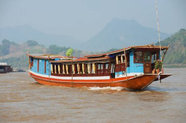 Luang Prabang, Laos - 12 Nisan 2012: Kimliği belirsiz kişi Luang Prabang, Laos Mekong Nehri tarafından geleneksel uzun tekne yolculuğu.