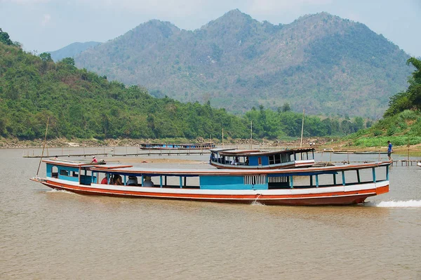Luang Prabang, Laos - 12 Nisan 2012: Kimliği belirsiz kişi Luang Prabang, Laos Mekong Nehri tarafından geleneksel uzun tekne yolculuğu.