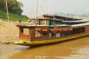 Luang Prabang, Laos - 12 Nisan 2012: Luang Prabang, Laos Kuru sezonunda Mekong Nehri'nin kıyısında kumlu bağlı geleneksel uzun tekneler görünümüne.