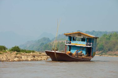 Luang Prabang, Laos - 12 Nisan 2012: Kargo gemi taşımaları teak ahşap günlükleri Mekong Nehri tarafından Kuru sezonunda Luang Prabang, Laos.