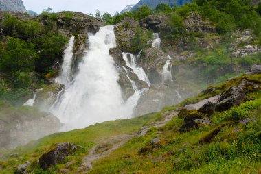 Picturesque waterfall with water melted from Jostedalsbreen Glacier, the biggest glacier in continental Europe located in Sogn og Fjordane county, Norway. clipart