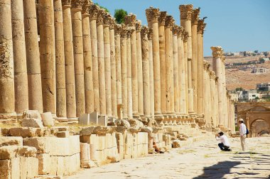 : Jerash, Jordan - 19 Ağustos 2012: Ürdün'Colonnade sokakta Gerasa antik Roma şehir (modern Jerash) kalıntıları tanımlanamayan turist ziyaret edin.