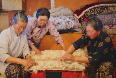 Harhorin, Moğolistan - 20 Ağustos 2006: Tanımlanamayan üst düzey Moğol kadınlar keçe Harhorin, Moğolistan'da üretmek. Keçe Moğolistan'da yurt izolasyon ve kış giysileri için temel malzemedir.