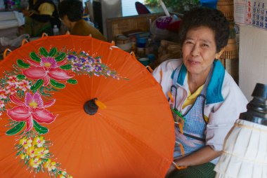 Chiang Mai, Tayland - 11 Kasım 2008: Kimliği belirsiz kadın kıdemli Tay geleneksel bambu şemsiye Chiang Mai, Tayland fabrikasında üretir.  