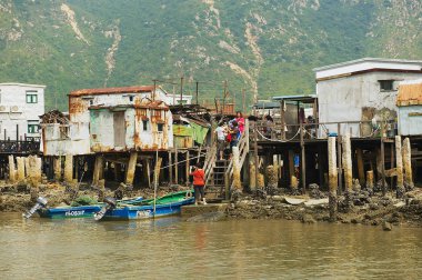 Hong Kong, Çin - 15 Eylül 2012: Turist Tai O balıkçı köyü tepedeki evlerin Hong Kong, Çin için ziyaret edin. Tai O Hong Kong ünlü bir turistik yer.