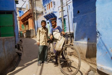 Jodhpur, Hindistan - 06 Nisan 2007: Tanımlanamayan gençler Jodhpur, Hindistan mavi boyalı evlerin dar sokak, eski bir bisiklet Standı ile.