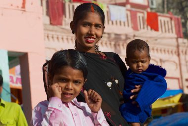 Varanasi, Hindistan - 25 Mart 2007: Varanasi, Hindistan'da kutsal Ganj Nehri, iki çocuklu bir kimliği belirsiz kadın hacı portresi.